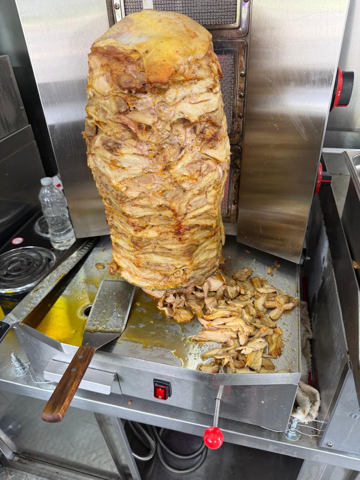 Chicken döner on the vertical spit, freshly sliced